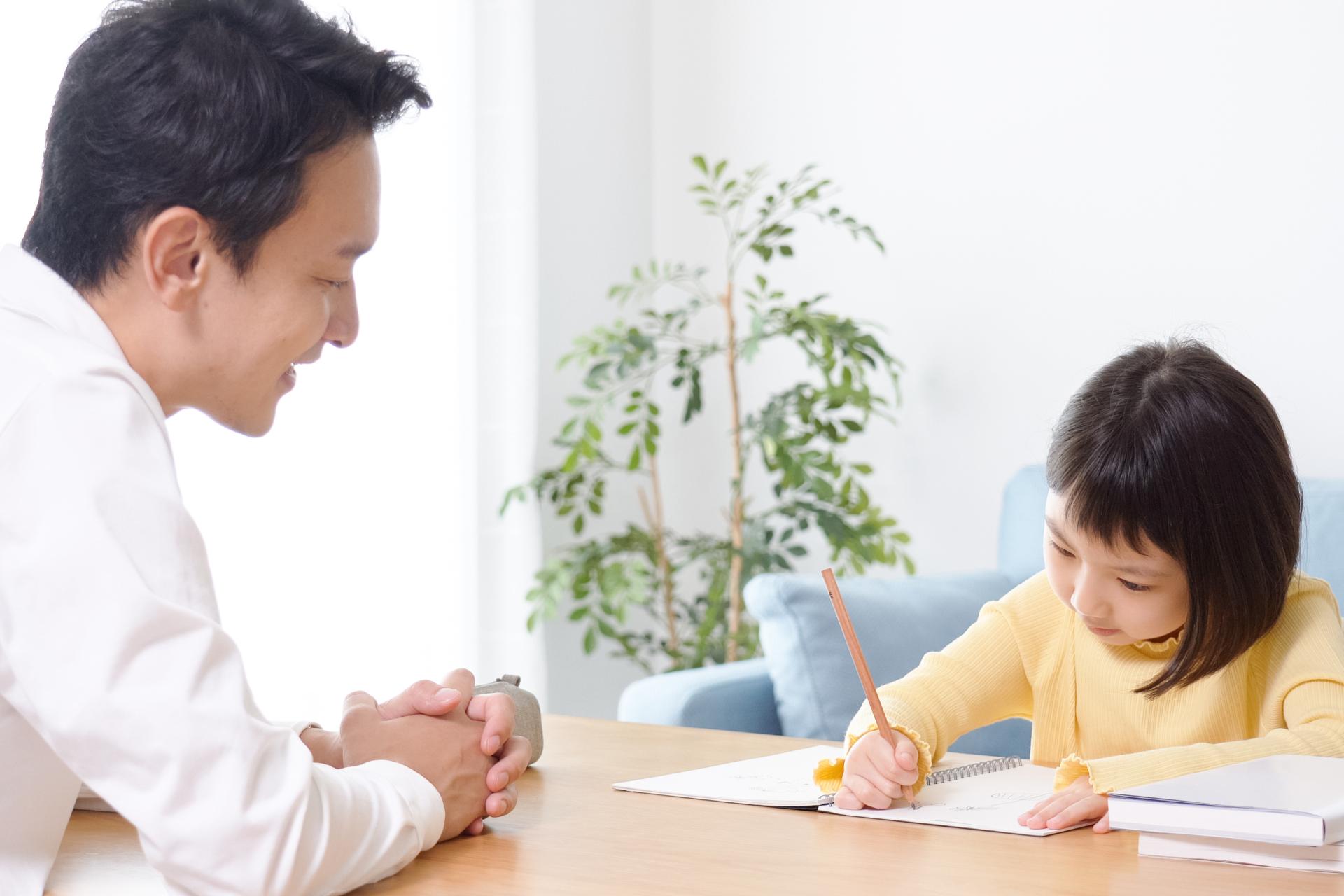 勉強をする生徒を先生が見守っている様子