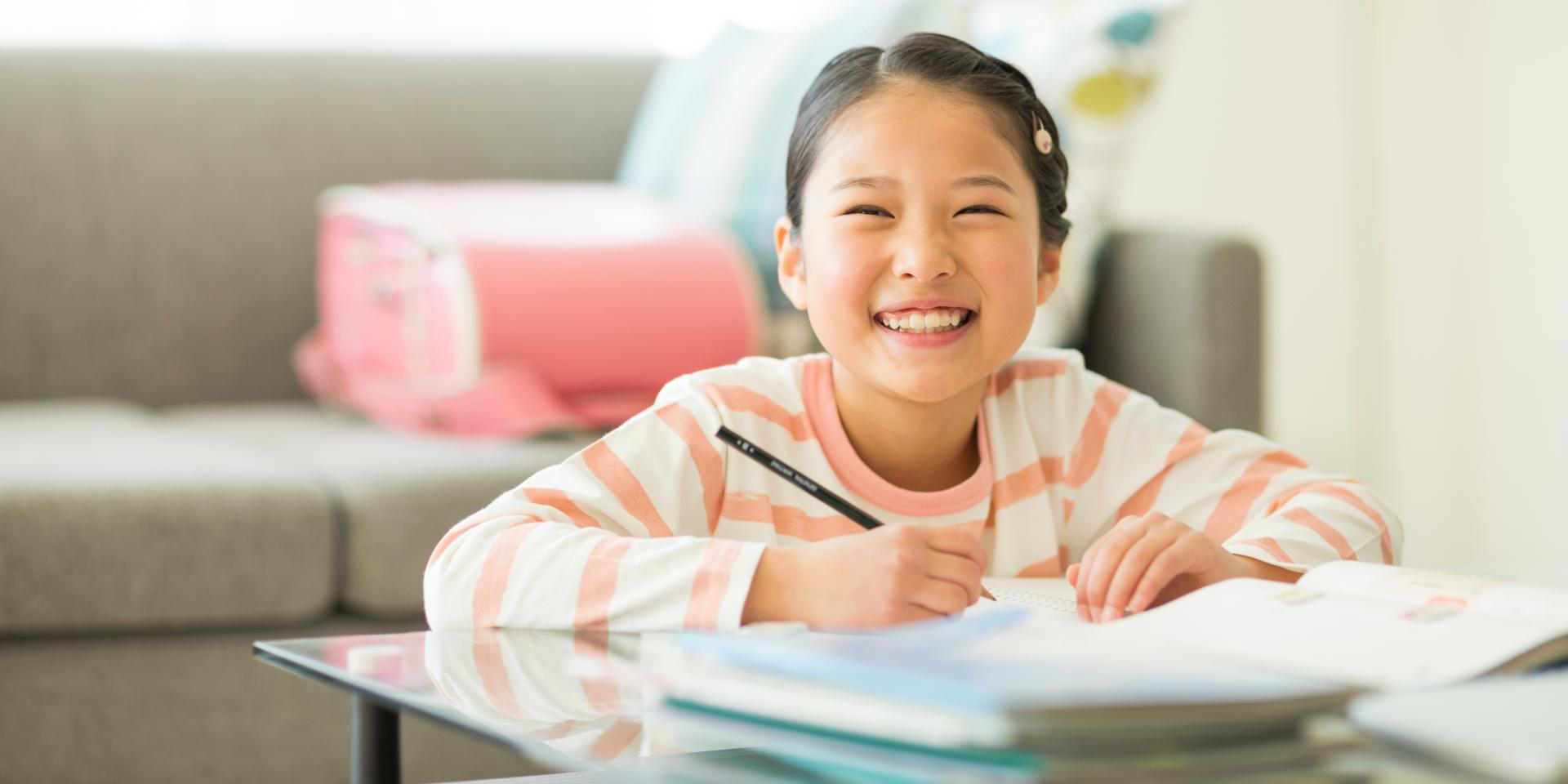 小学生が笑顔で勉強をしている様子